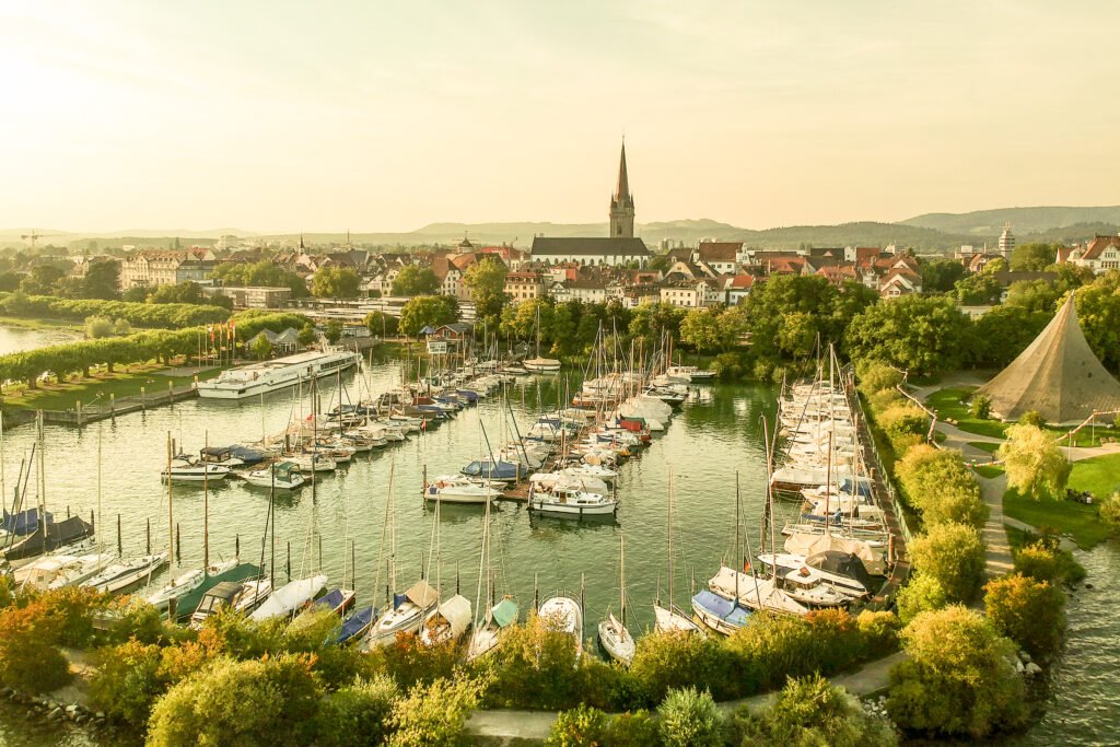 Panorama-Luftaufnahme einer Hafenstadt am Rhein mit Segelbooten — Editorial-Imagemotiv für Tourismusmarketing und Regionalbr…